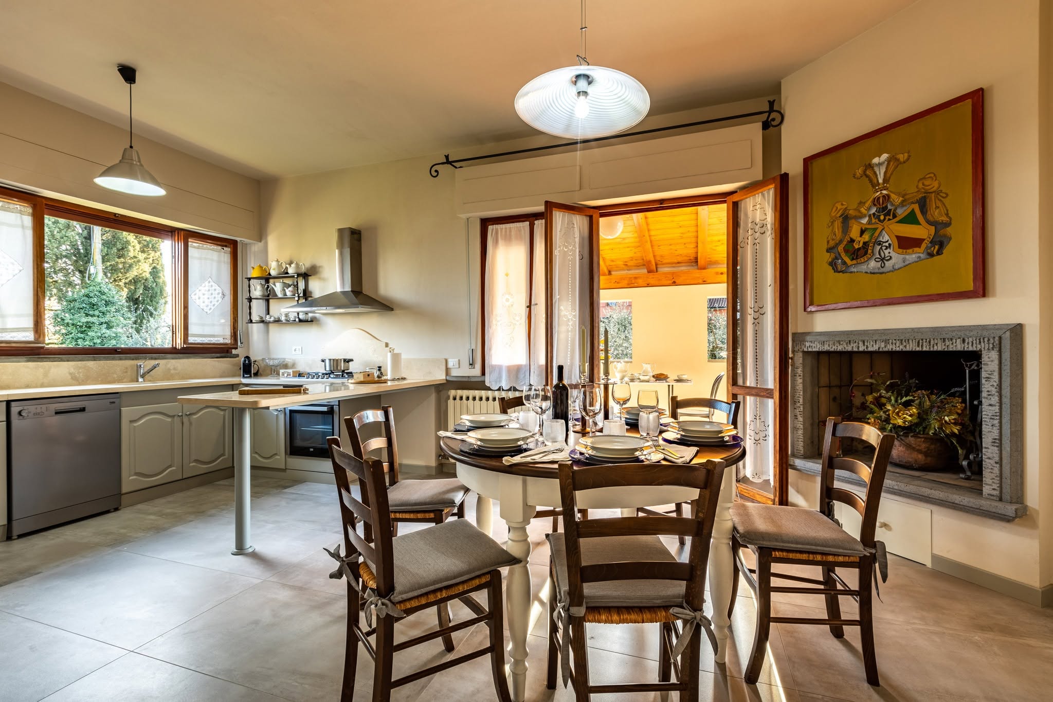 Sala da pranzo con tavolo rotondo, camino e cucina completa