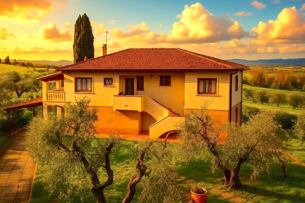 A vibrant Tuscan villa with golden-yellow walls and terracotta roof, surrounded by mature olive trees against a dramatic sunset sky with golden clouds